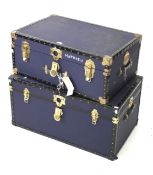 Two contemporary streamer trunks and a quantity of coat hangers.