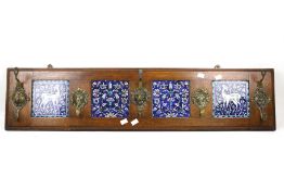 A set of coat hooks. Mounted on an oak board with four iznik blue tiles.