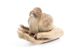 A two piece hard wood sculpture of a bird and a hand.