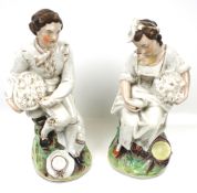 A pair of Staffordshire figures. Modelled as a man and woman holding baskets, Max.