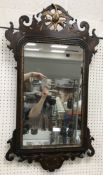 A walnut fretwork carved wall mirror wit
