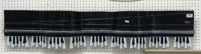 A glass wall sculpture of a grand piano