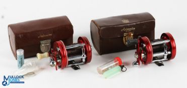 2x ABU Ambassadeur 6000 multiplier reels both in red finish, one stamped 080701, the other with no