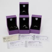 Five silver rings of varying styles set with black diamonds (and one surrounded by white