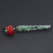 A 14k yellow gold ring set with an oval cabochon cut red stone (possibly coral or carnelian?) with