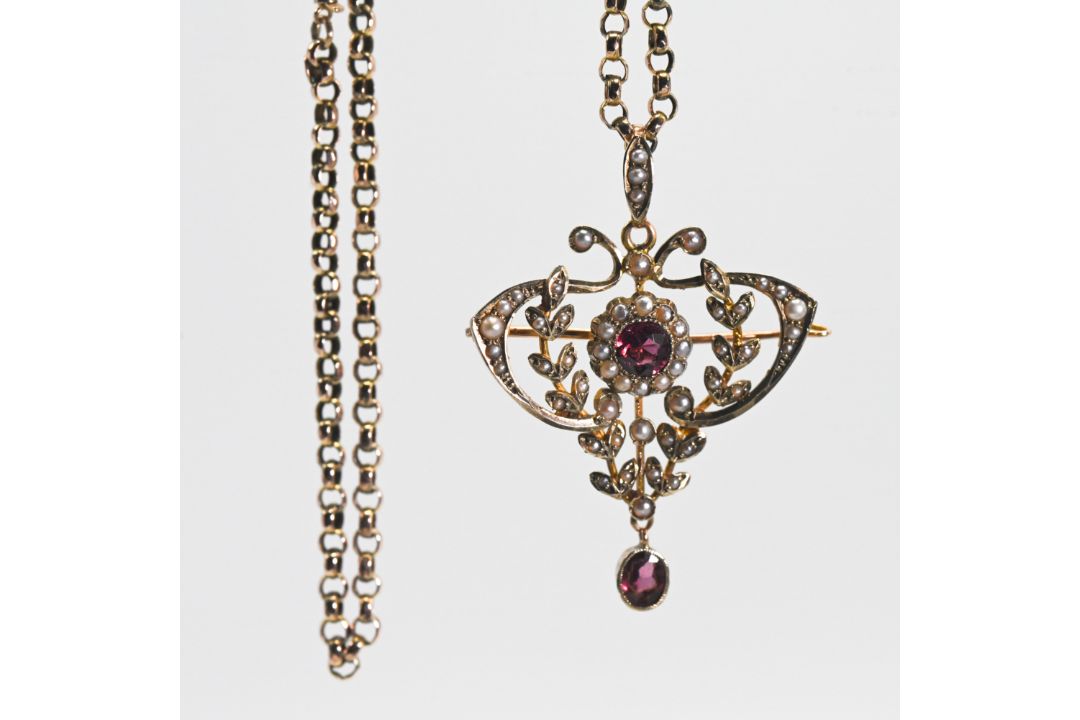 An ornate Victorian pendant with brooch fitting set with seed pearls and garnets, measuring