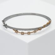 An 18ct white gold bangle with a rose gold twist, set with a total weight of 0.96 carats of round
