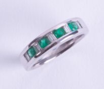 An 18ct white gold half eternity style ring set with four round cut emeralds