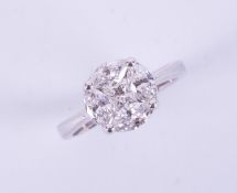 An 18ct white gold ring in a circular design set with a central princess cut diamond