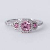 An 18ct white gold ring set with a central pink sapphire with a round pink sapphire to each side