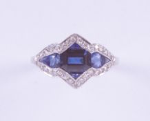 A platinum Art Deco ring (no hallmarks) set with a central emerald cut sapphire