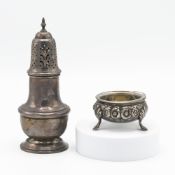 A silver ornate flower engraved three legged salt dish with a glass liner (glass liner cracked &