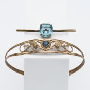 A 9ct gold blue stone bangle decorated with leaves together with a 9ct gold blue stone brooch,