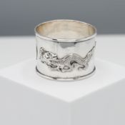 A Chinese silver napkin ring of cylindrical form, cast in relief with two dragons either side of a