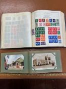 A small album of postcards including some from Hong Kong together with an album of stamps (2).