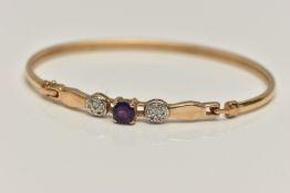 A 9CT GOLD GEM SET BANGLE, set with a central circular cut amethyst, flanked with single cut diamond
