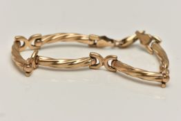 A 9CT GOLD FANCY LINK BRACELET, designed as a series of curved textured bars, fitted with a