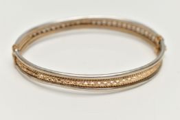 A 9CT BICOLOUR HINGED BRACELET, AF yellow gold textured and pierced centre with white gold edges,