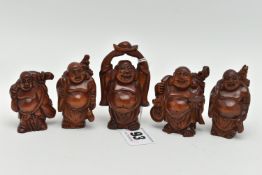 FOUR 20TH CENTURY CARVED TREEN OKIMONO AND A NETSUKE, all in the form of standing buddha, all with