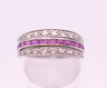 A white metal (possibly platinum) diamond, ruby and sapphire night and day ring. Ring size M. 4.