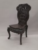 An Oriental ebonised carved wooden chair. 56 cm wide.