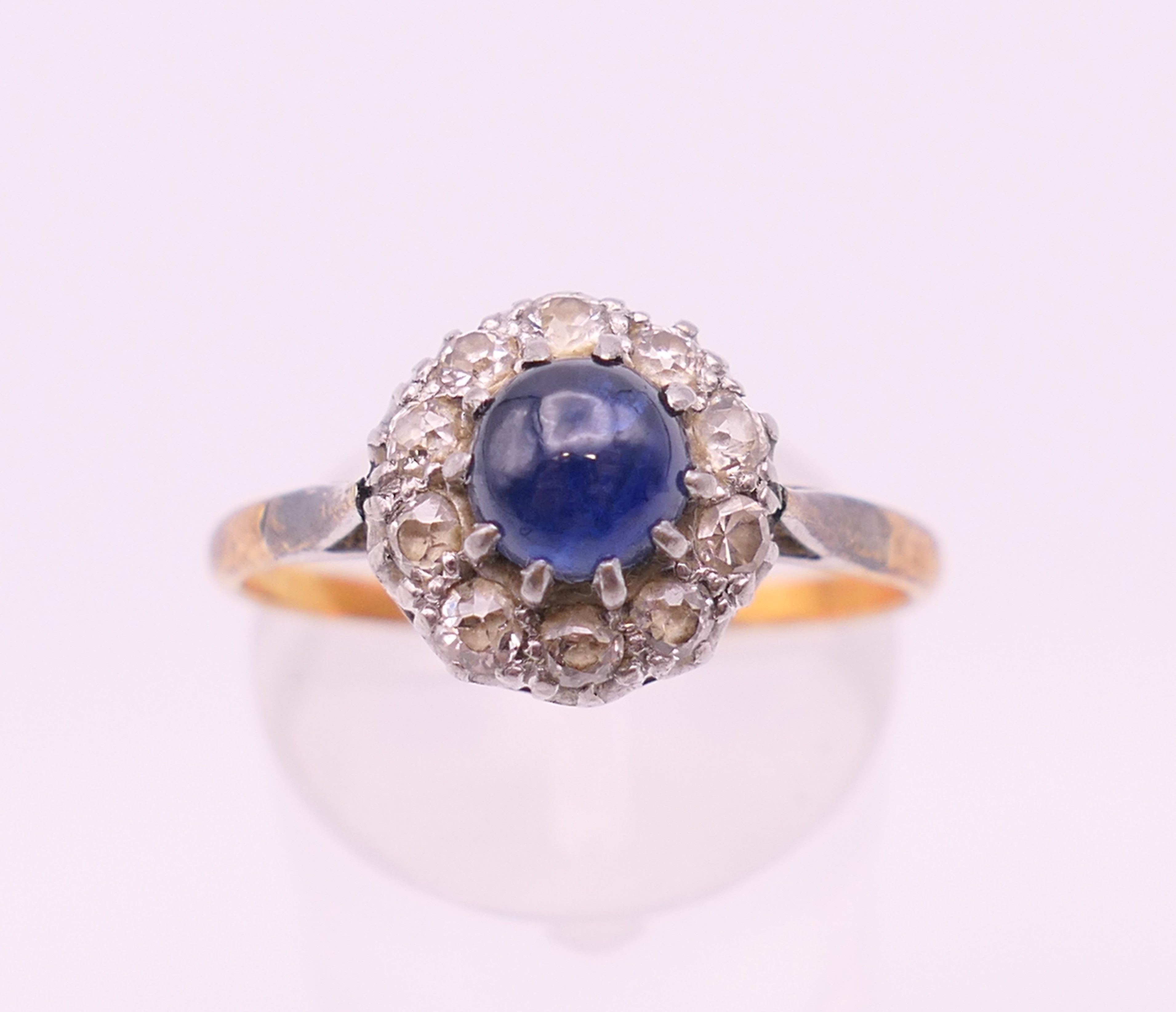 An 18 ct gold and platinum cabochon sapphire and diamond cluster ring. Ring size Q. - Image 3 of 7