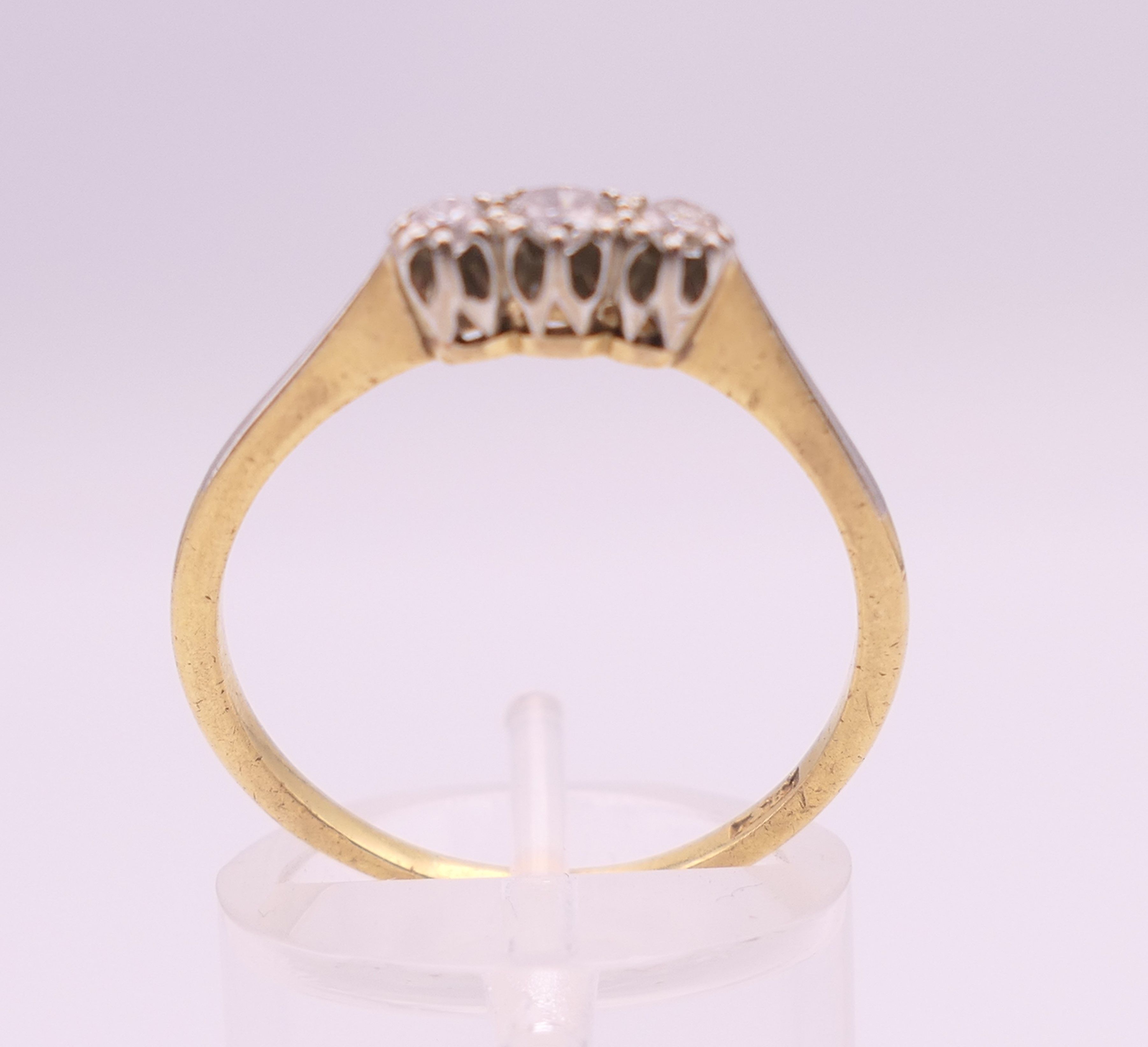 An 18 ct gold three stone diamond ring. Ring size R/S. 2.6 grammes total weight. - Image 3 of 5