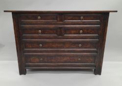 A carved oak chest of drawers. 122 cm wide.