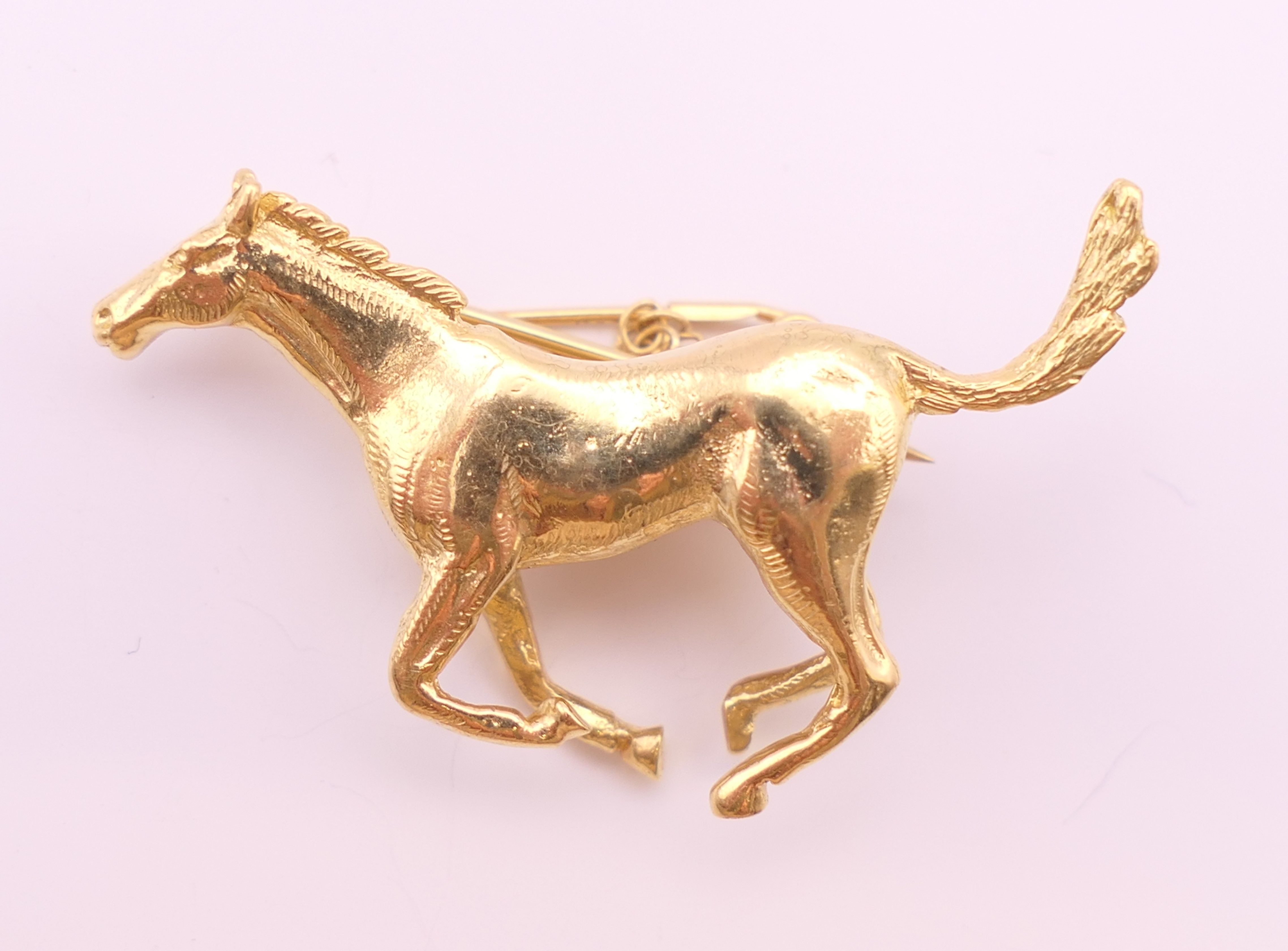 An 18 ct gold galloping horse form brooch. 3.75 cm wide x 2.5 cm high. 12.5 grammes. - Image 2 of 4