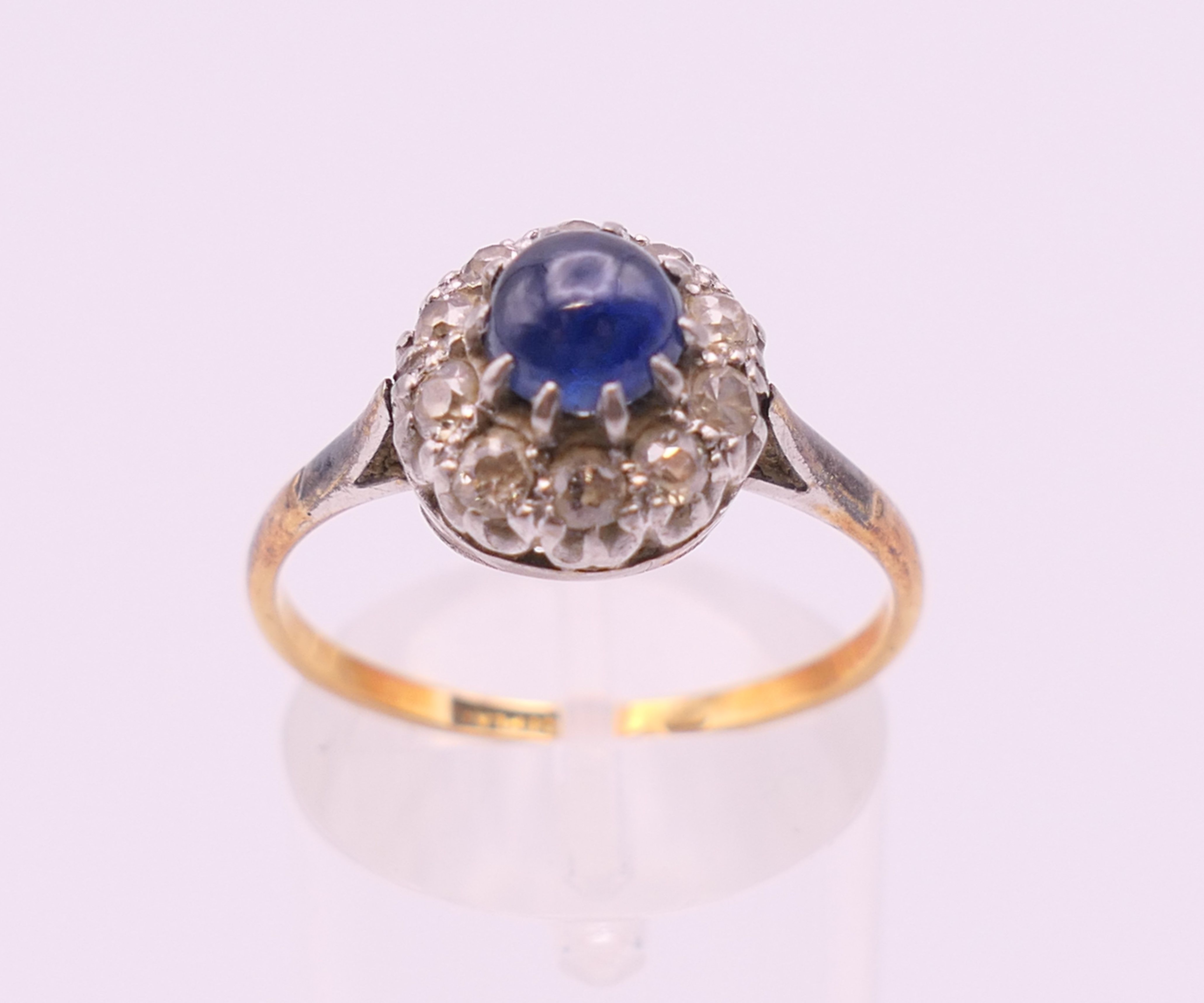 An 18 ct gold and platinum cabochon sapphire and diamond cluster ring. Ring size Q. - Image 2 of 7