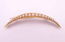 A 15 ct gold, seed pearl crescent moon form brooch. 5 cm high. 3.7 grammes total weight.