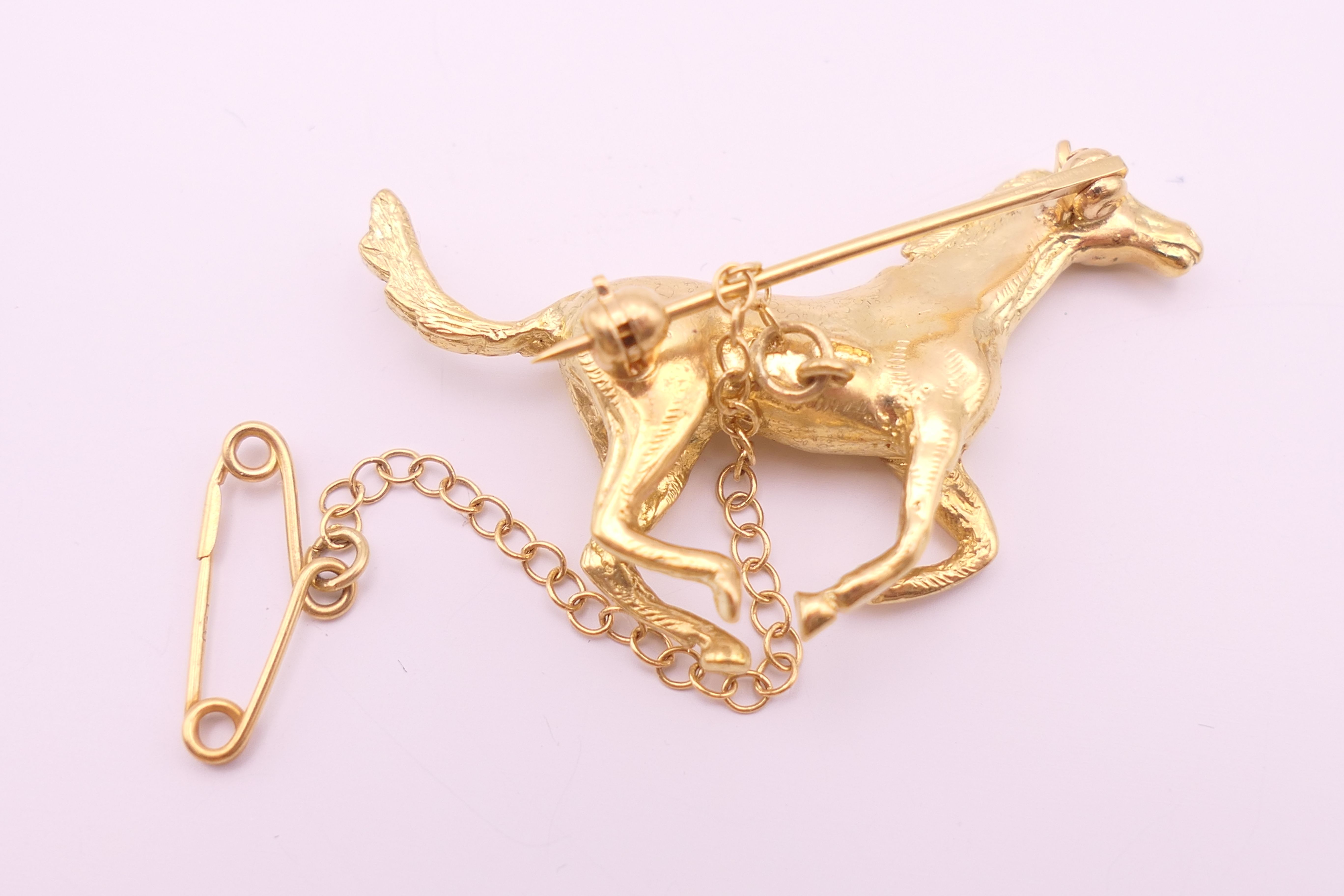 An 18 ct gold galloping horse form brooch. 3.75 cm wide x 2.5 cm high. 12.5 grammes. - Image 3 of 4