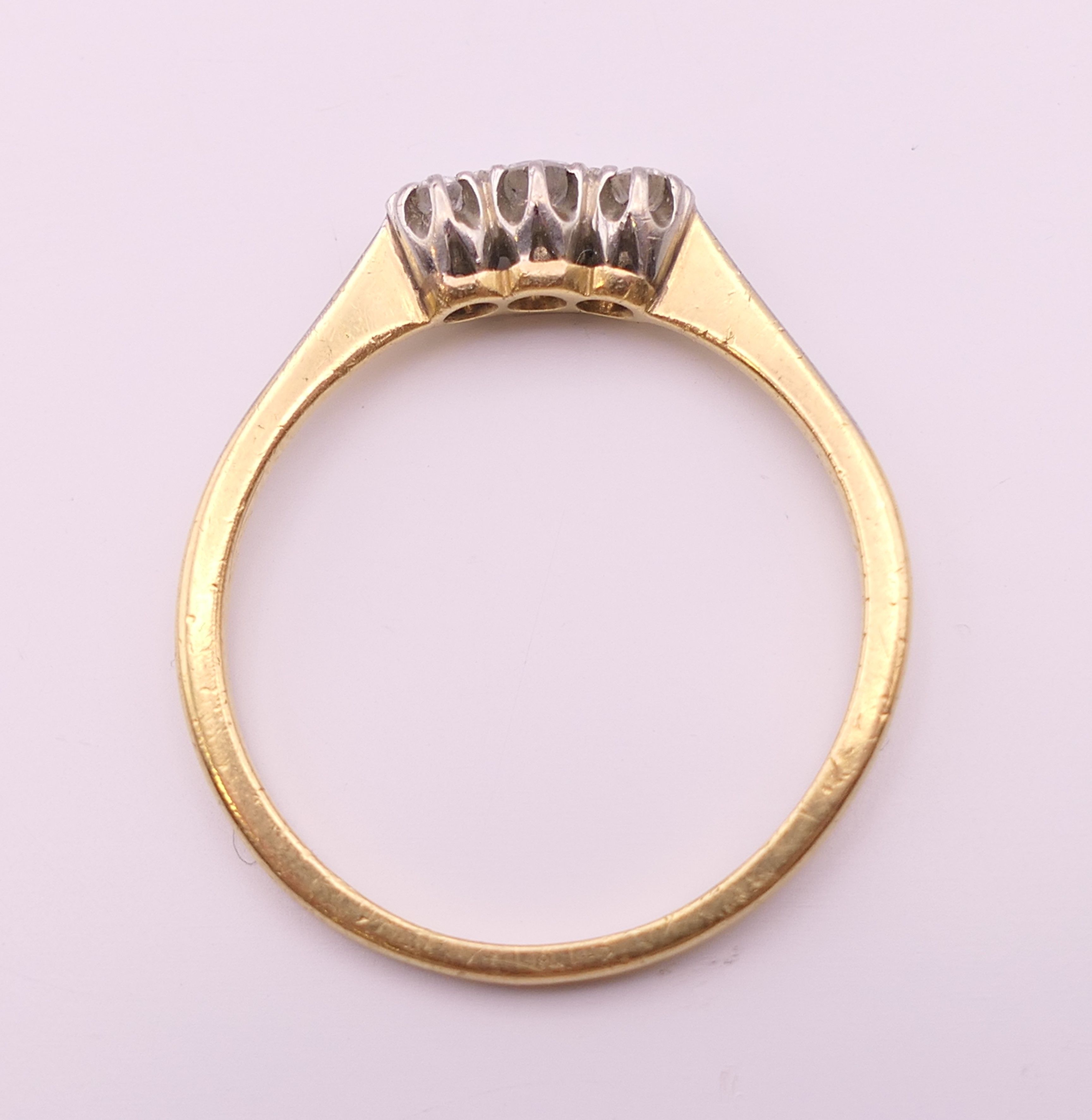 An 18 ct gold three stone diamond ring. Ring size R/S. 2.6 grammes total weight. - Image 4 of 5
