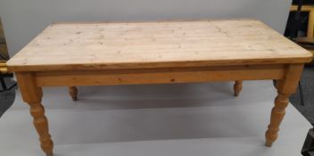 A large pine kitchen table and eight kitchen chairs. 183 x 95 cm.