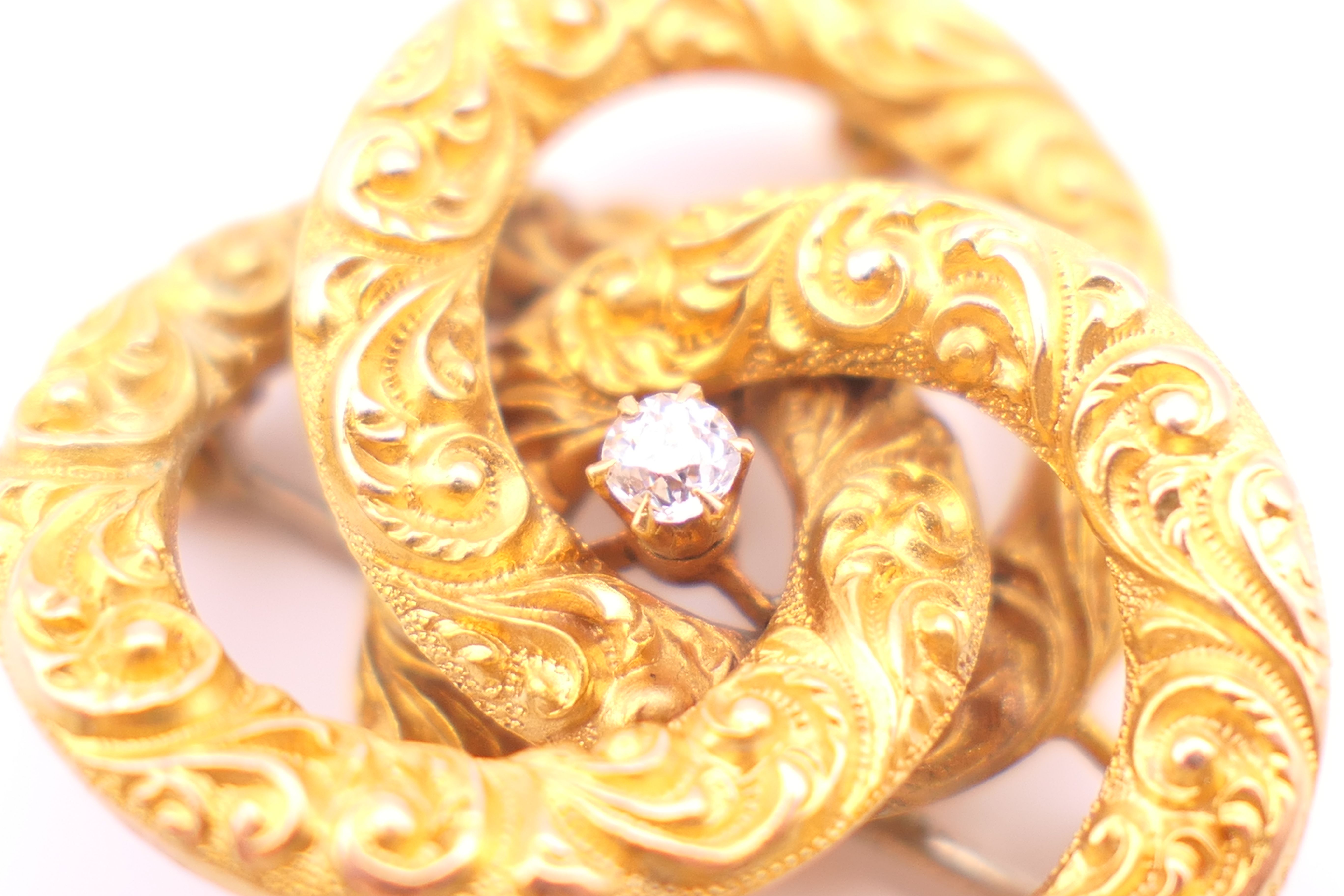 An unmarked 15 ct gold and diamond brooch/pendant formed as three interlocking circles. - Image 4 of 4