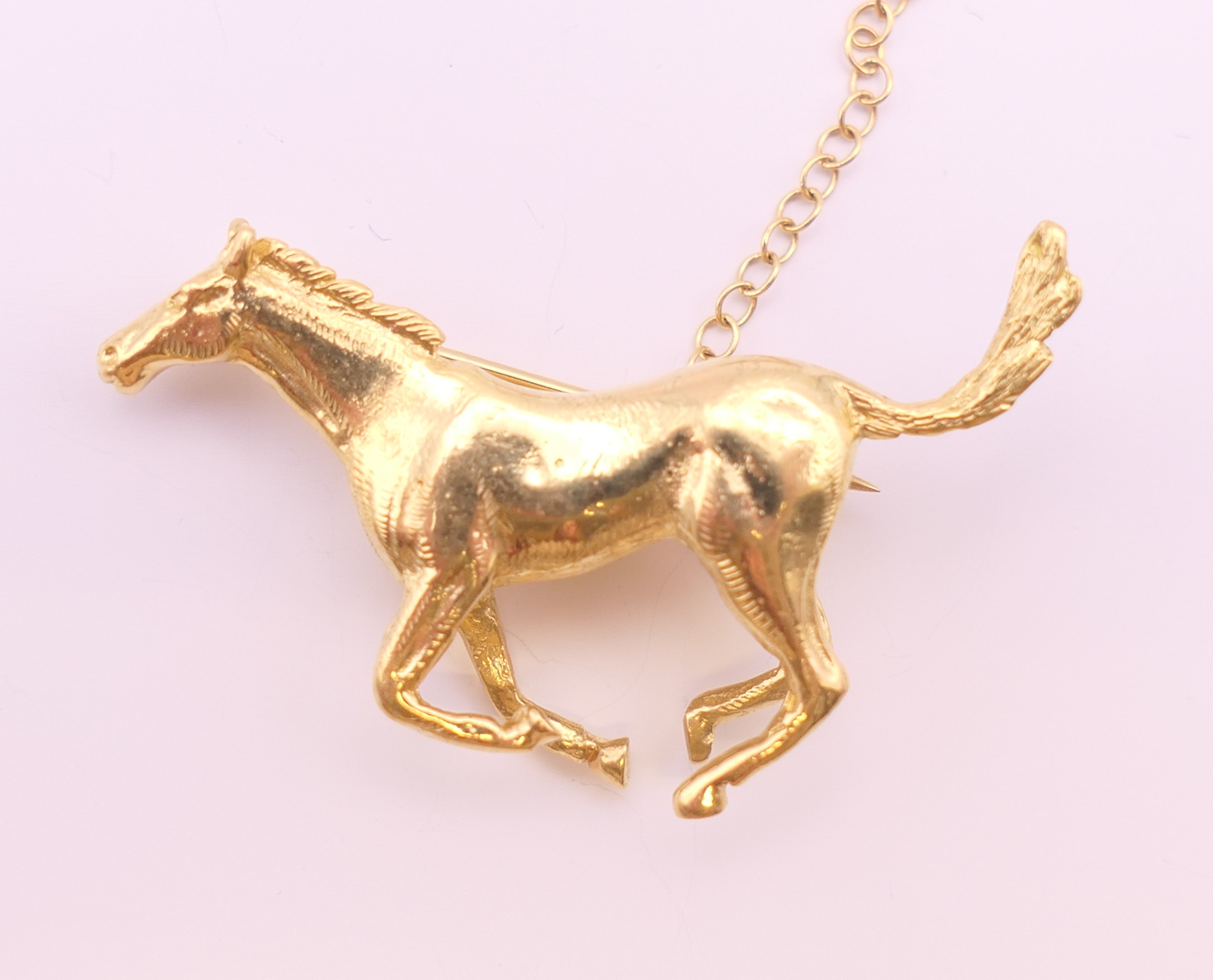 An 18 ct gold galloping horse form brooch. 3.75 cm wide x 2.5 cm high. 12.5 grammes.