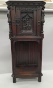 A 19th century carved oak side cupboard. 135 cm high.