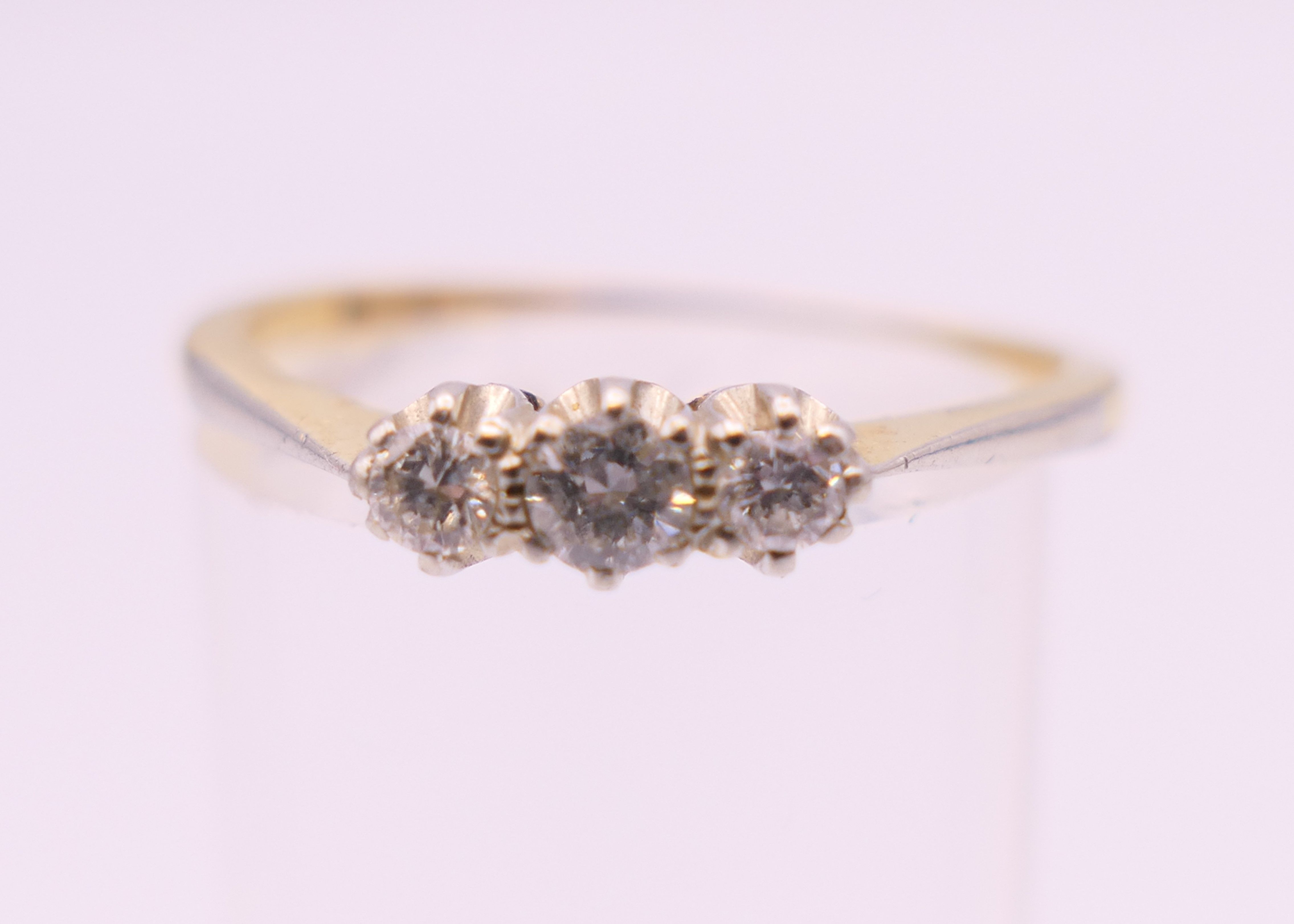 An 18 ct gold three stone diamond ring. Ring size R/S. 2.6 grammes total weight. - Image 2 of 5