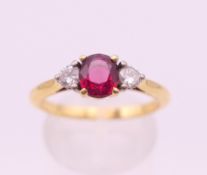 An Asprey 18 ct gold ruby and diamond three stone ring. Ring size Q.
