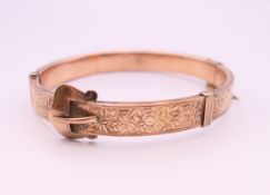 A 9 ct gold buckle form bangle bracelet. 5.75 cm internal diameter. 12.4 grammes total weight.