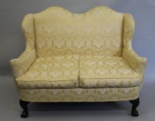An early 20th century upholstered double camel back settee. 143 cm wide.