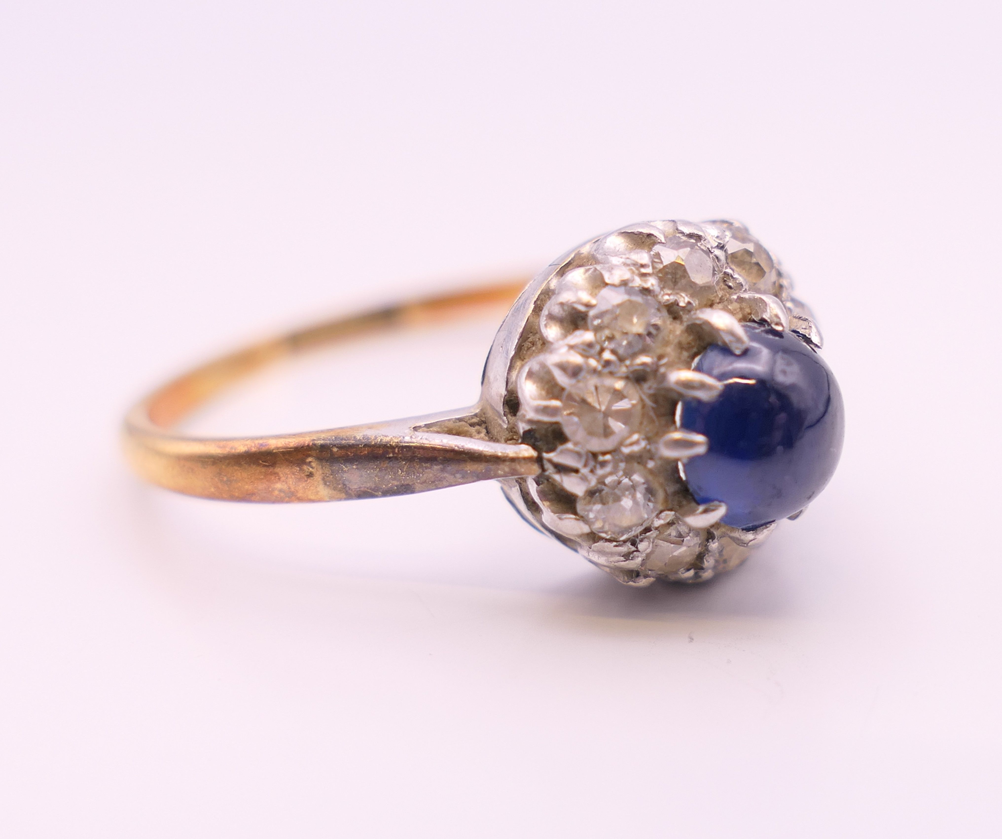 An 18 ct gold and platinum cabochon sapphire and diamond cluster ring. Ring size Q. - Image 6 of 7