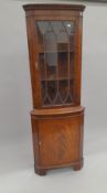 A reproduction mahogany corner cupboard. 181 cm high.