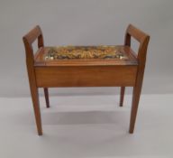 An Edwardian upholstered piano stool. 63 cm wide.