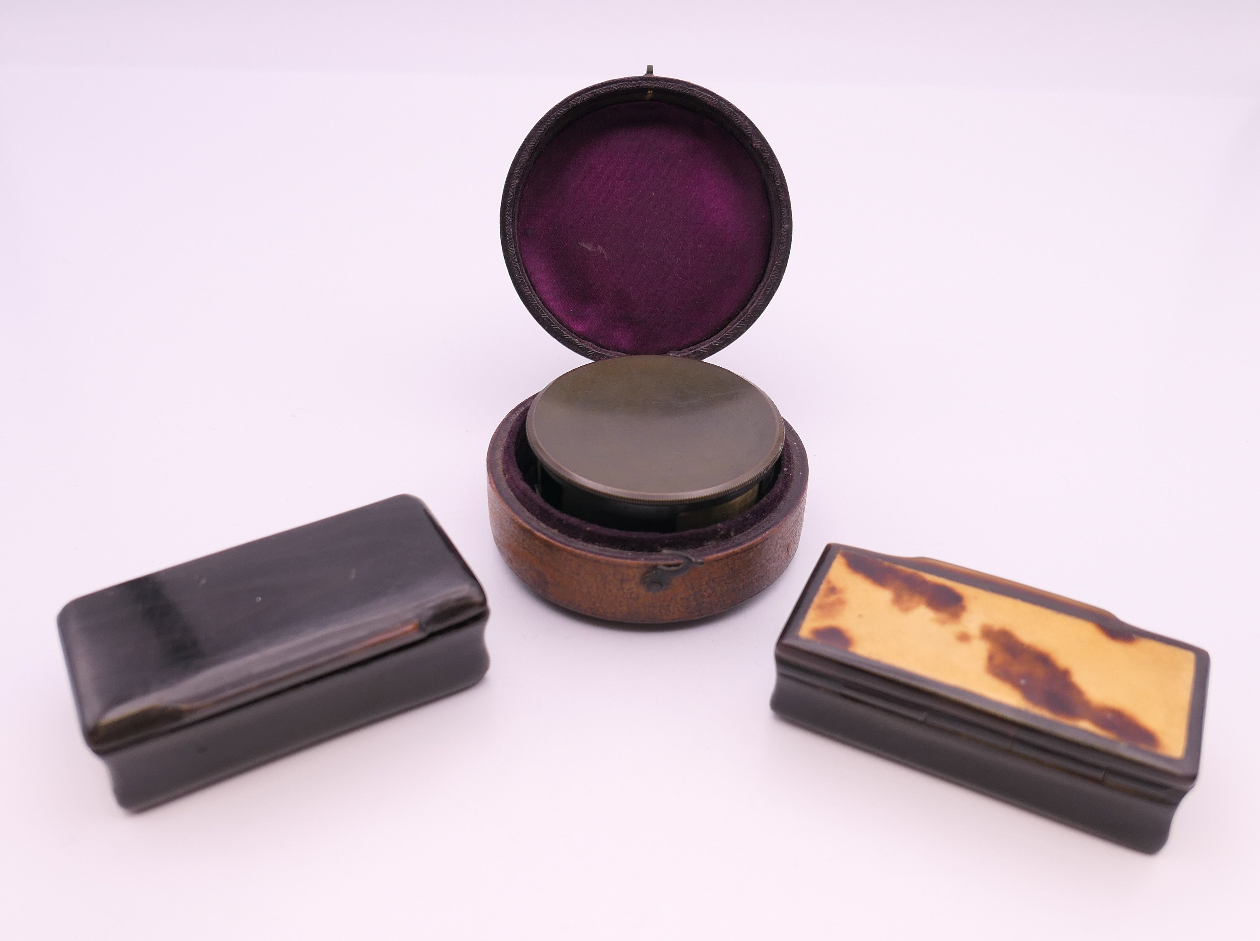 A cased pocket clinometer and two snuff boxes.