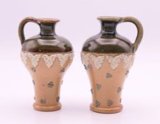 A pair of Doulton stoneware miniature jugs. Tallest 7.5 cm high.