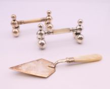 A pair of EPNS and mother-of-pearl knife rests, and an EPNS and mother-of pearl trowel.