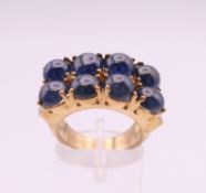 A 9 ct gold ring set with eight cabachon sapphires flanked by six small diamonds. Ring size N. 10.