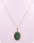 A 9 ct gold and malachite pendant on a 9 ct gold chain.