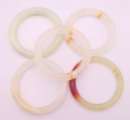 Five various jade bangles. Approximately 6 cm internal diameter.